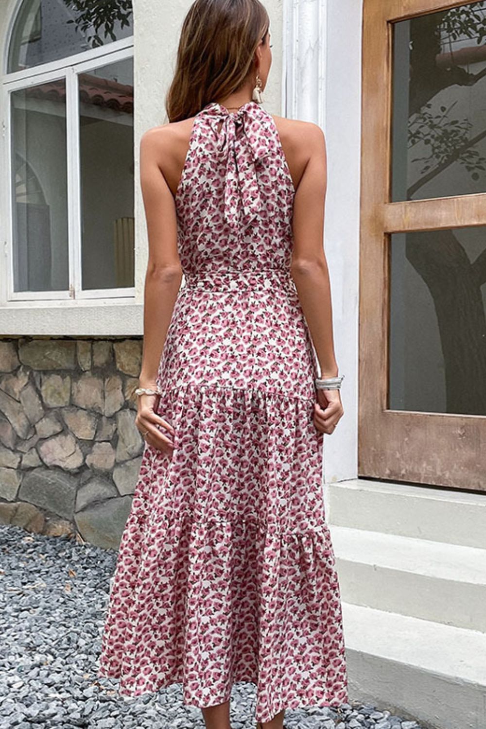 Woman wearing pink floral print tiered midi dress