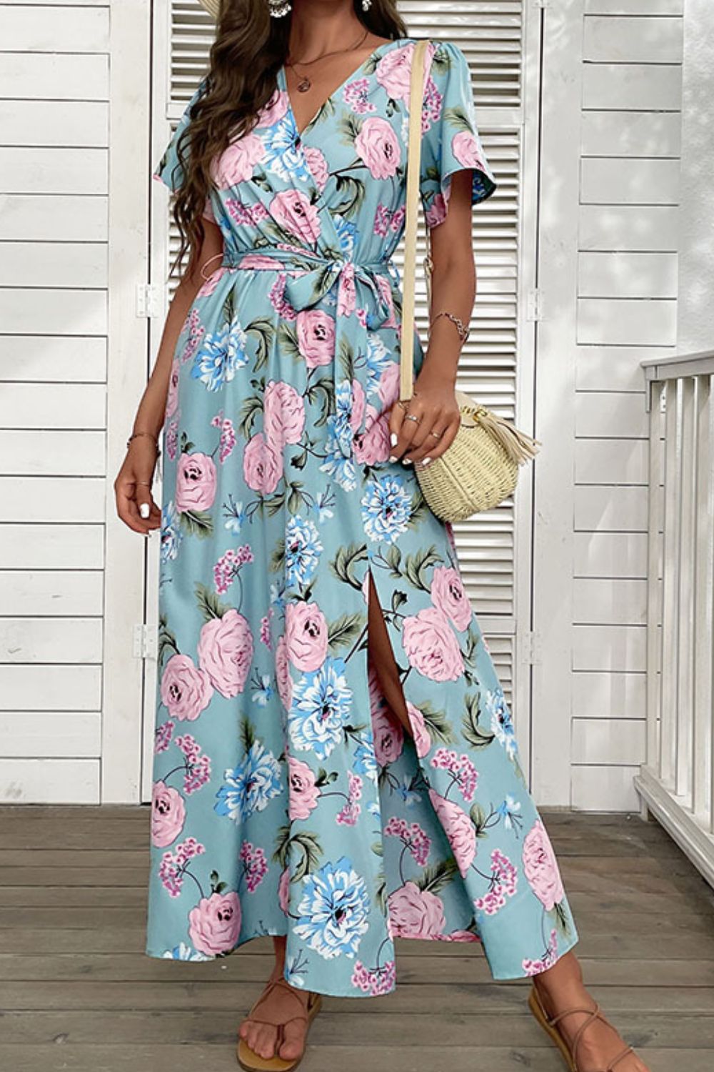 Woman wearing blue floral side slit surplice maxi dress